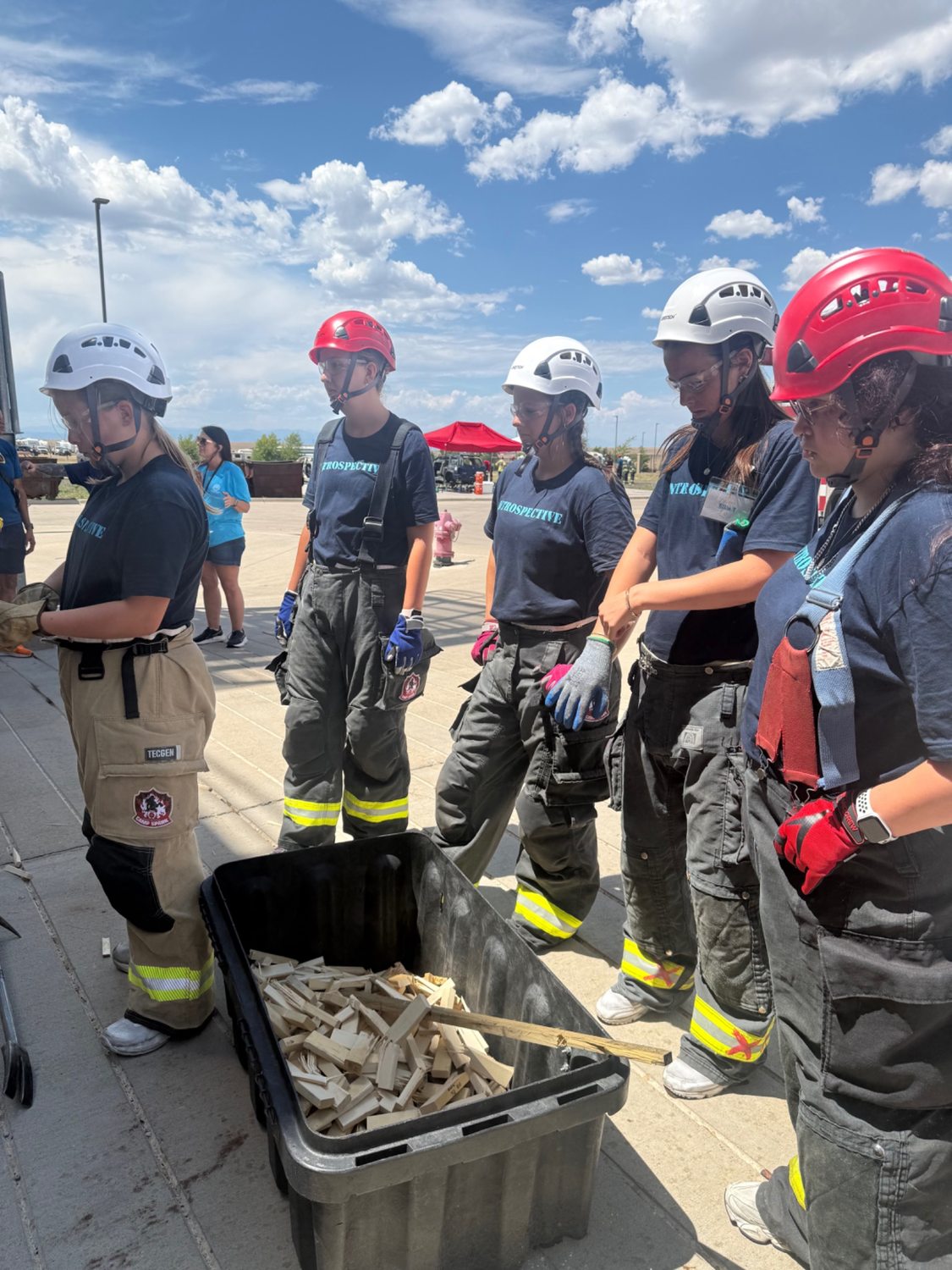 Camp Spark participants wear helmets and turnout gear during a hands-on exercise